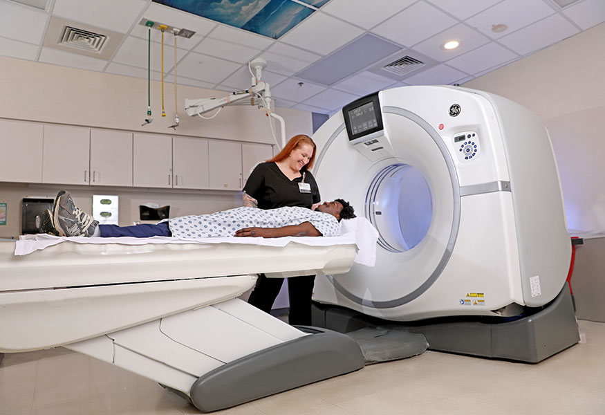 Imaging technician preparing a patient for a CT scan.