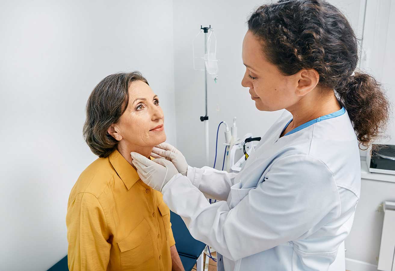 A female doctor examining a woman's lymph nodes. 