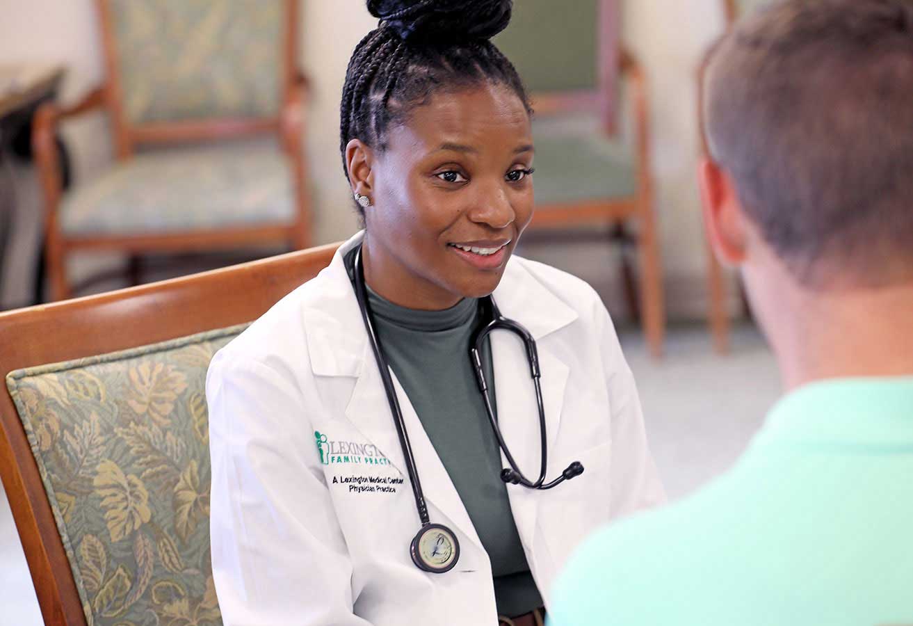 A smiling female doctor speaking with a patient.