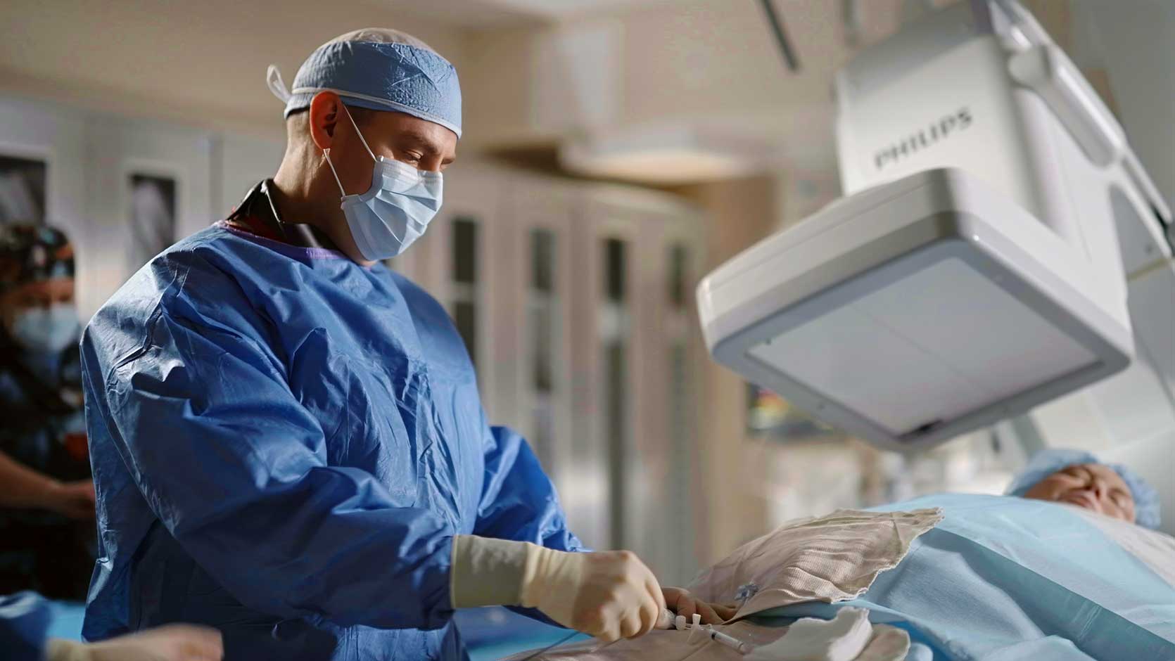 Surgeon performing a procedure on a patient.