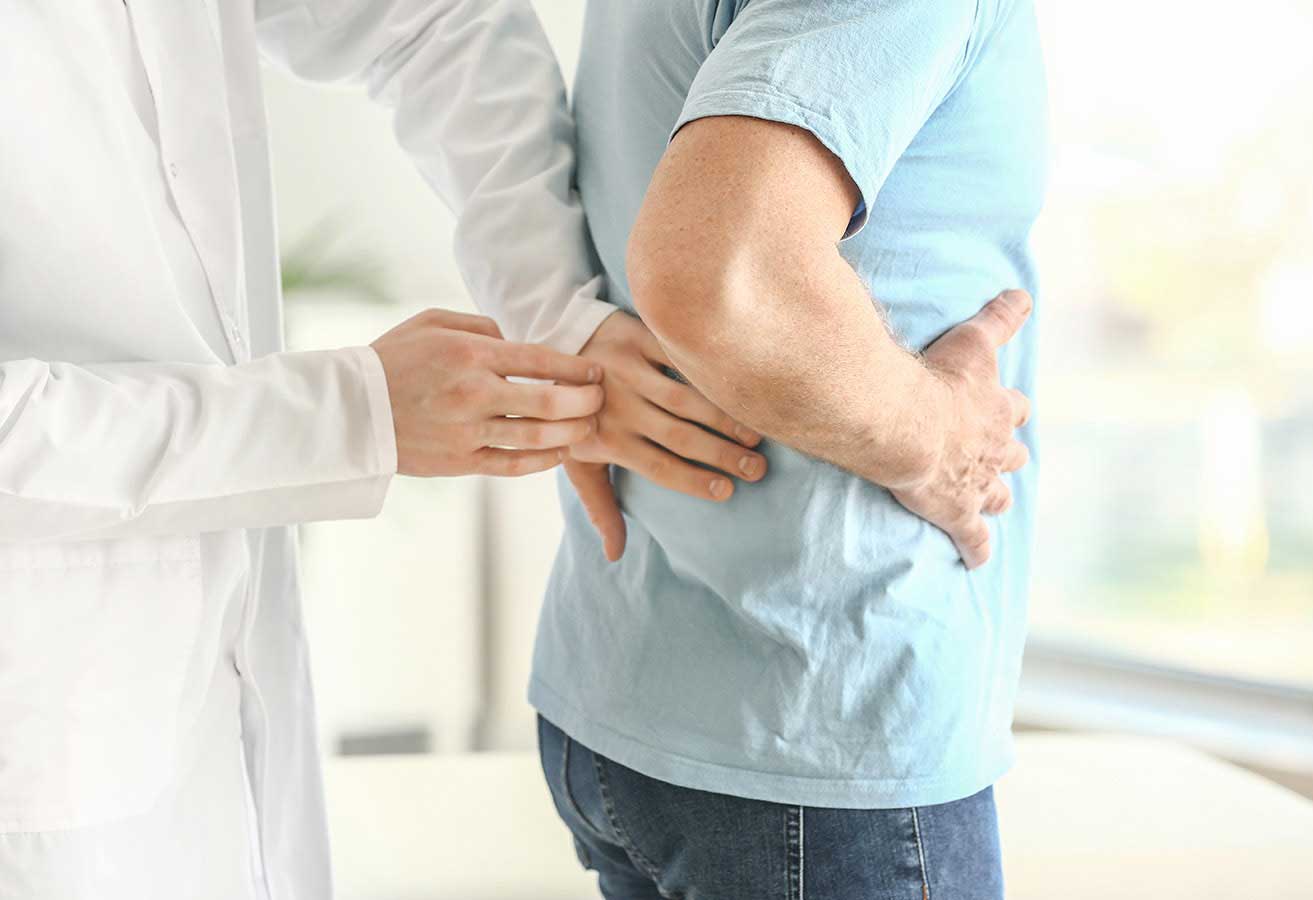 A doctor examining a patient's lower back. 