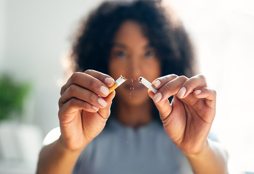 Woman breaking a cigarette in half.